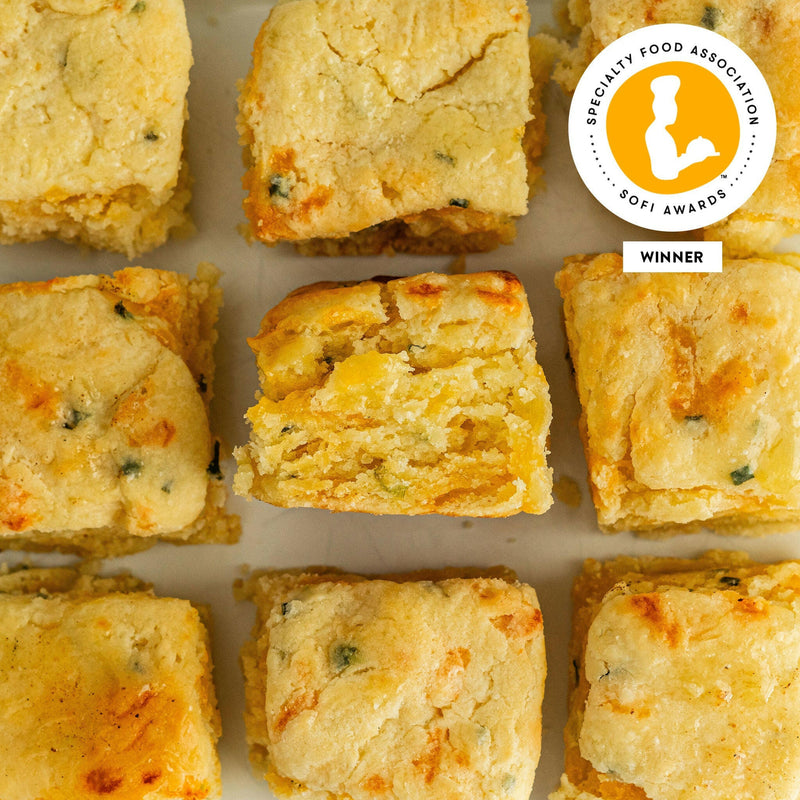 Callie's Hot Little Biscuit | Frozen Biscuits - Cheese + Chive, showcasing close-up baked goods with a savory blend of cheddar and chives, ideal for diverse meals.