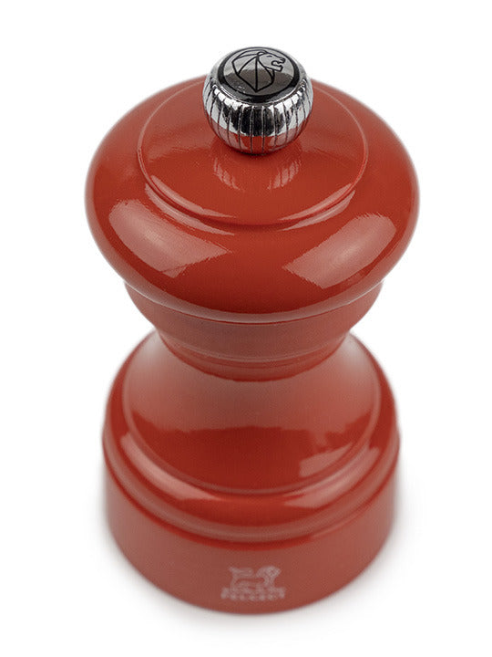 Peugeot | Bistro Pepper Mill, Terracotta: A glossy red, wood-look manual grinder with a metal adjustment knob, crafted from sustainably sourced French wood, ideal for gourmet cooking.