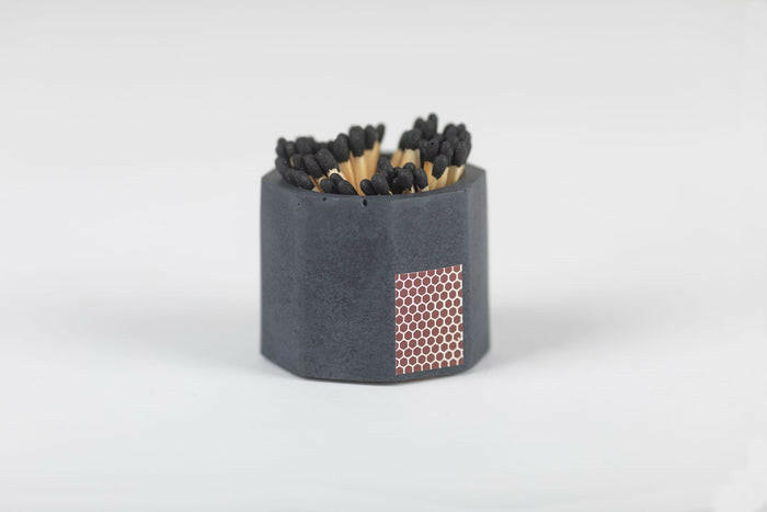 Tenn Prairie match holder with striker, featuring a grey concrete cylinder and black matches, perfect for safe and stylish lighting in your kitchen.