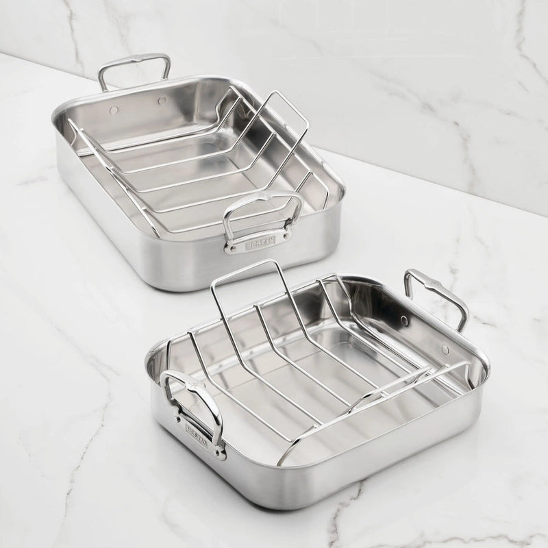 Hestan Provisions | Classic Roaster with Rack, 14.5 Inches, featuring two stainless-steel pans with wire racks on a marble countertop; ideal for versatile cooking.