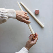 A person holds The Floral Society | Copper Candle Sharpener, showcasing its sleek design, a unique tool available at Athens Cooks for enhancing candle use.