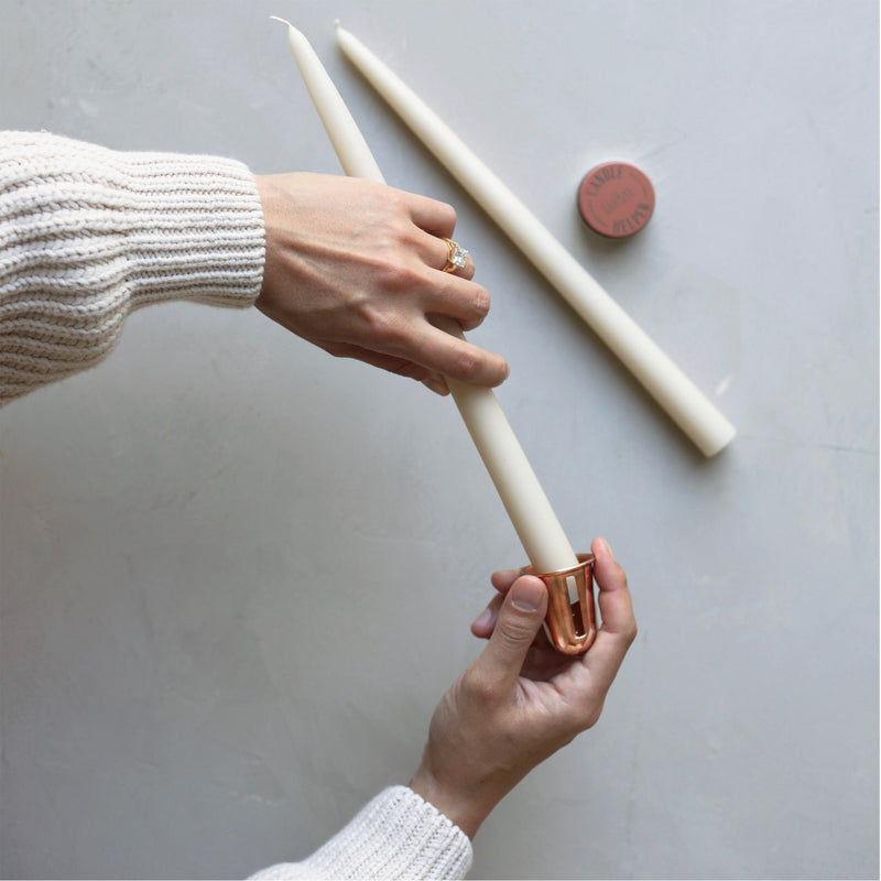 A person holds The Floral Society | Copper Candle Sharpener, showcasing its sleek design, a unique tool available at Athens Cooks for enhancing candle use.