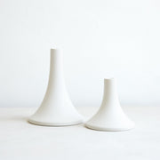 The Floral Society | Candle Holders, Grand, Matte White Tall: Two elegant, flared-base ceramic holders in varied heights, designed for standard taper candles, offering a sleek, handcrafted finish.