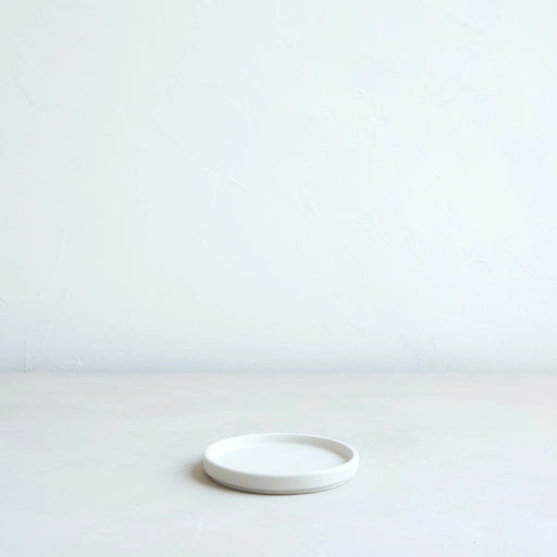 The Floral Society's Daily Plate, Matte White, sits centered, showcasing its wide, stable base, perfect for candles or as a versatile kitchen accessory.
