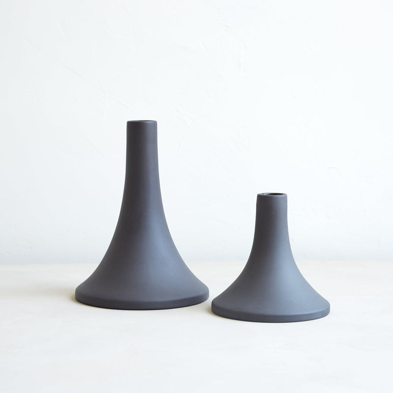 The Floral Society | Candle Holders, Grand, Matte White Tall: Two ceramic candlestick holders, one tall and slender, the other short with a wide base, perfect for standard taper candles.
