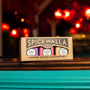 Spicewalla | Chai Pani Restaurant Collection, 3-Pack Gift Set featuring Garam Masala, Tandoori Masala, and Madras Curry Powder jars on a wooden countertop.