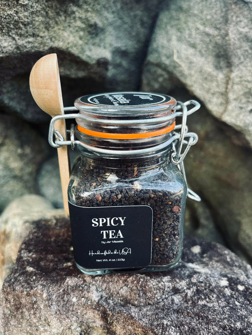 Jar of Masala Chai Tea with a wooden spoon, showcasing premium spice and black tea blend crafted by a women-owned artisanal company.