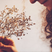 Monfort | Brut Rosé Trentodoc bottle held among flowers, highlighting its elegance and vibrant profile, ideal for celebrations and pairing with diverse dishes.