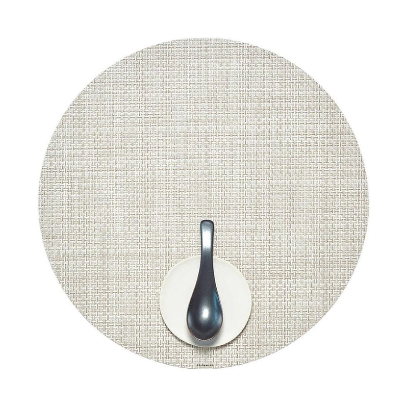 Chilewich | Mini Basketweave Round Placemats - Natural, featuring a subtle texture, displayed beneath a spoon on a plate, perfect for enhancing dining experiences.