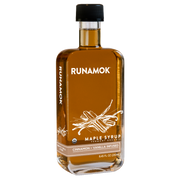 Runamok's Cinnamon + Vanilla Infused Maple Syrup in a glass bottle, ideal for enhancing pancakes or coffee with warm, spiced flavors.