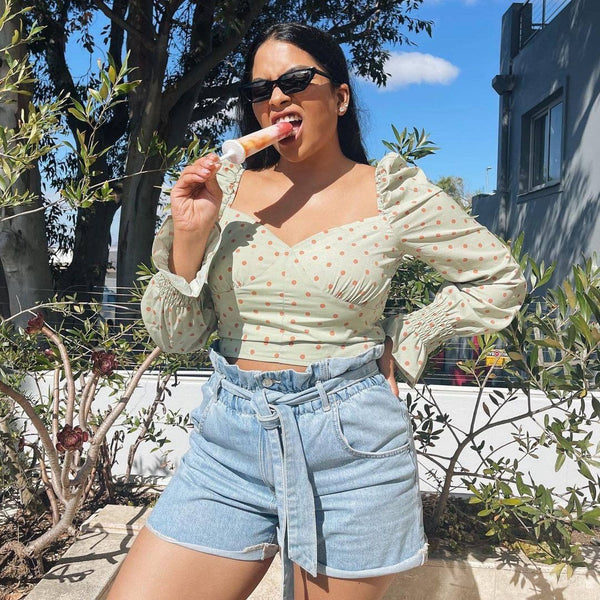 A woman enjoys ice cream outdoors, highlighting the Zoku | Classic Pop Mold, perfect for crafting homemade frozen treats, available at Athens Cooks.