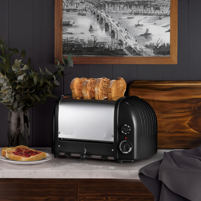 Dualit | 4 Slice Classic Toaster, Matt Black, with golden-brown toast, showcased in a stylish kitchen setting, emphasizing quality craftsmanship and functionality.