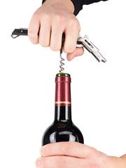 Hands using the Peugeot Clavelin Sommelier Corkscrew to smoothly open a wine bottle, highlighting its patented handle mechanism for effortless cork removal.