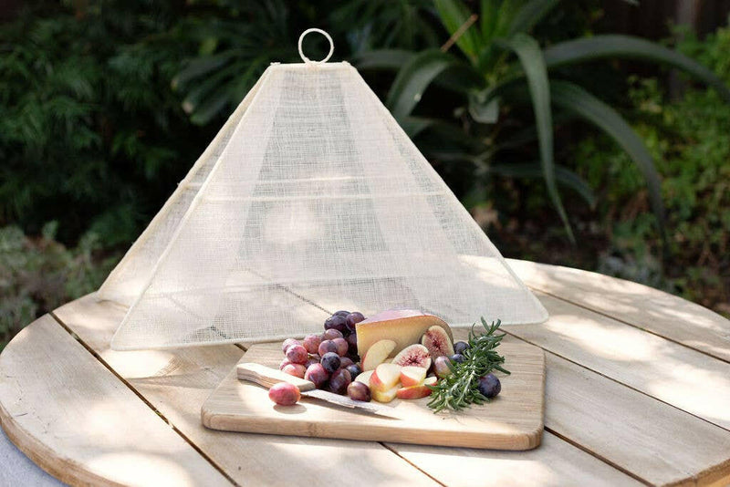 NEEPA HUT | Collapsible Woven Food Tent - Rose Pink, elegantly covering fruit and cheese platter outdoors, showcasing its unique pentagon shape and foldable design for easy transport.