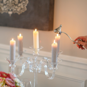 Arte Italica & Crown Linen Designs | Lucia Snuffer elegantly extinguishing a gray taper candle on a glass candelabra, highlighting Italian craftsmanship amidst a floral dining setting.