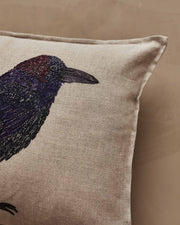 Coral & Tusk | Blackbird with Acorn Pillow: Linen cushion featuring an embroidered crow motif with vibrant feathers and an acorn, symbolizing new beginnings.