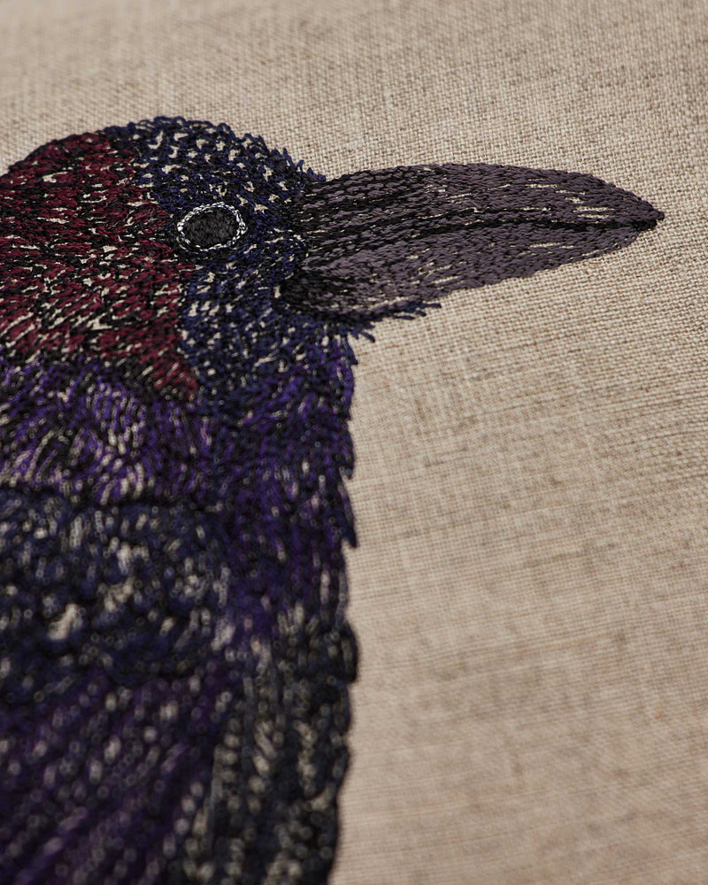 Coral & Tusk | Blackbird with Acorn Pillow features vibrant embroidered feathers and an acorn, symbolizing new beginnings. Perfect for adding artistic flair to your kitchen decor.