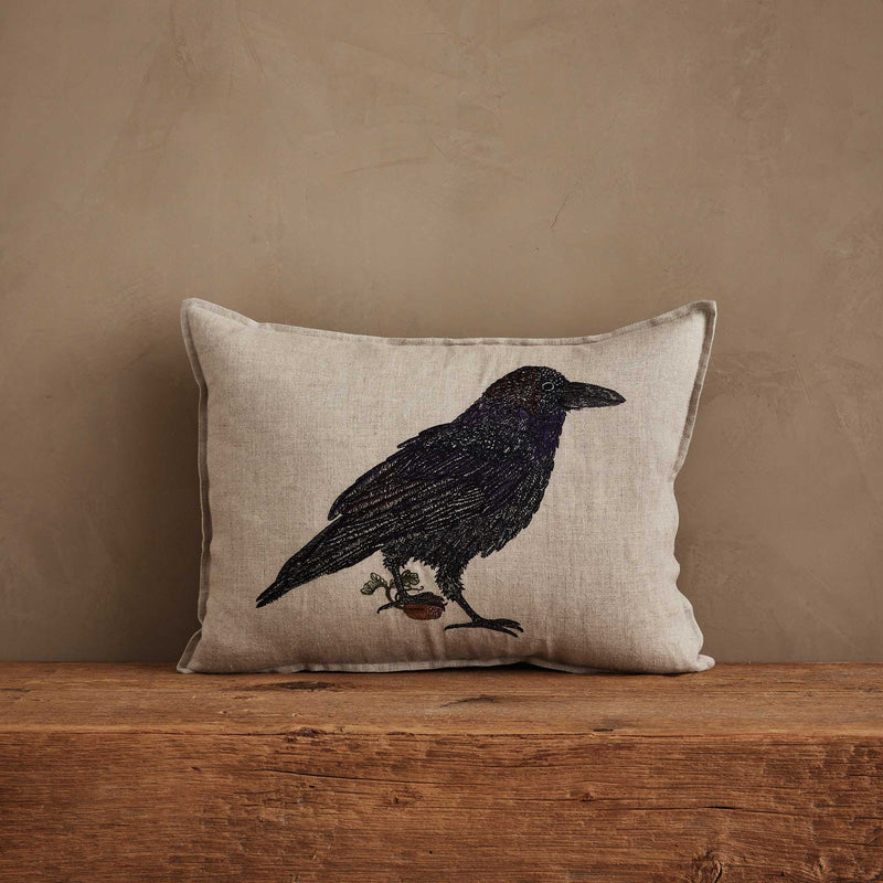 Coral & Tusk | Blackbird with Acorn Pillow: Linen pillow with embroidered crow, acorn, and sprig, embodying rustic charm and new beginnings.