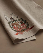 Coral & Tusk | Togetherness Tea Towel featuring a festive woodland scene with embroidered deer, foxes, and an owl around a fir wreath, ideal for seasonal kitchen decor.