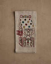 Coral & Tusk | Cookie Workshop Tea Towel: A festive linen tea towel embroidered with a gingerbread house, featuring holiday motifs, perfect for adding Christmas cheer to your kitchen.