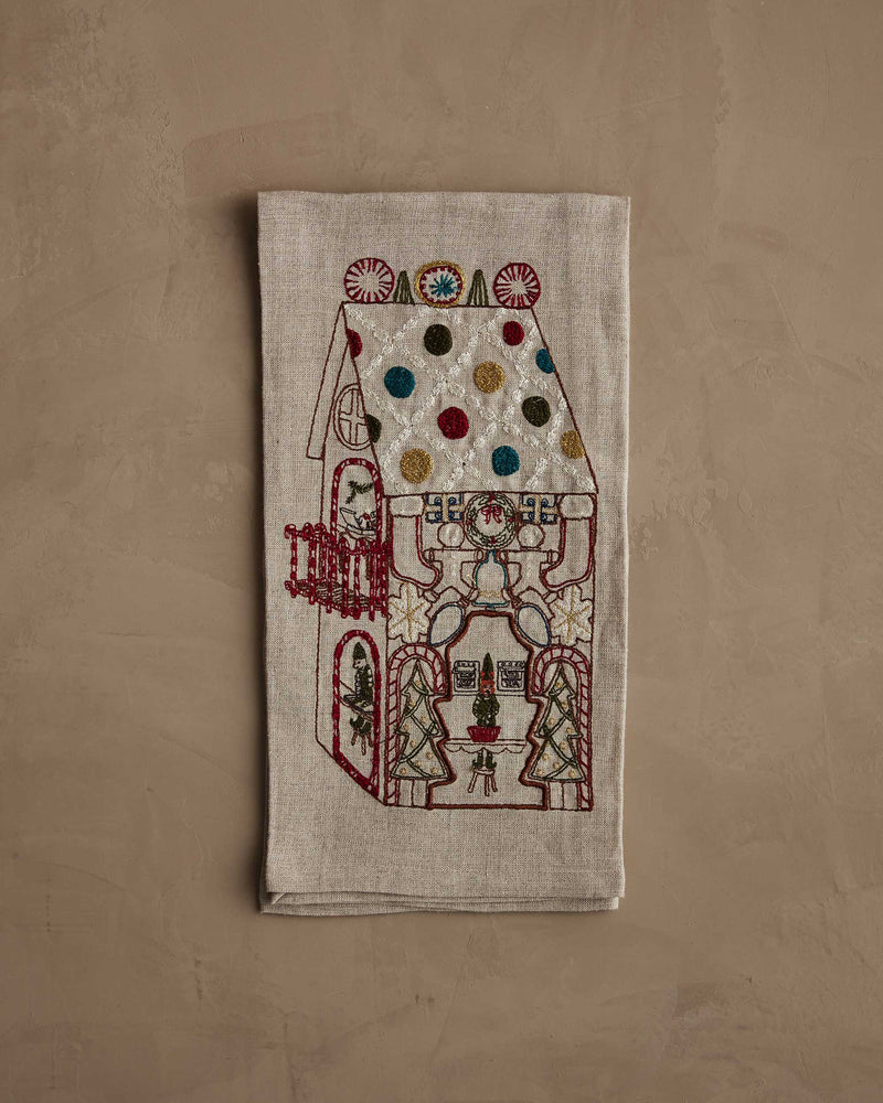 Coral & Tusk | Cookie Workshop Tea Towel: A festive linen tea towel embroidered with a gingerbread house, featuring holiday motifs, perfect for adding Christmas cheer to your kitchen.