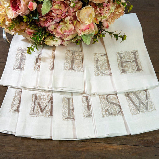 Crown Linen Designs | Monogram Linen Towel - R elegantly displayed beside a floral bouquet, showcasing its embroidered detail, perfect for elevating kitchen or bathroom decor.