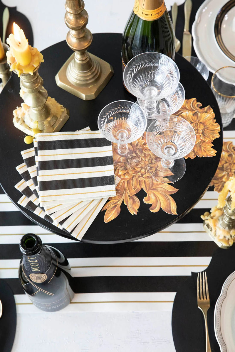 Hester & Cook's Gold Celebration Collection Black & Gold Awning Stripe Cocktail Napkins feature elegant foil accents, perfect for elevating any festive gathering.