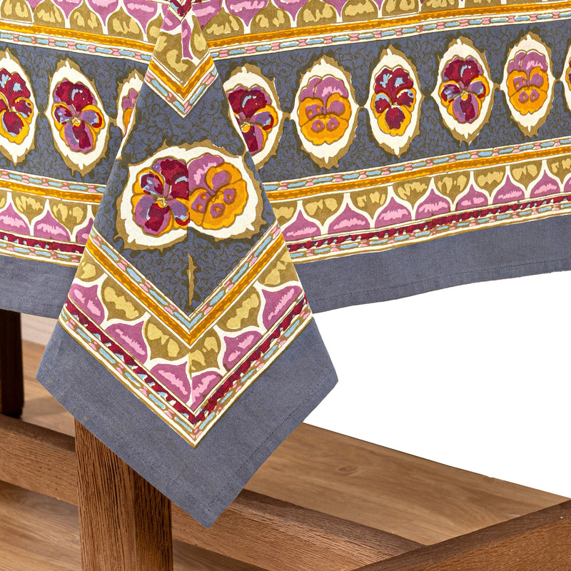 Caravan Home | 71 x 71 Pansy Red & Grey Tablecloth features vibrant floral and abstract patterns, handprinted on French linen, embodying unique craftsmanship.