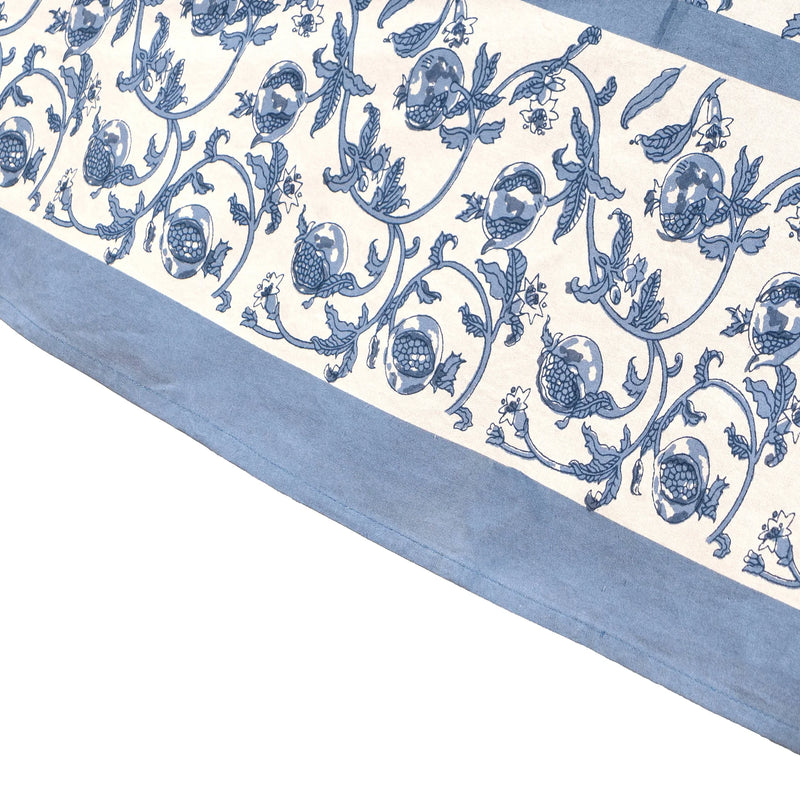 Granada Cornflower Blue Tablecloth, 59 x 86, featuring a hand-printed floral and pomegranate design on high-quality linen, suitable for various dining settings.