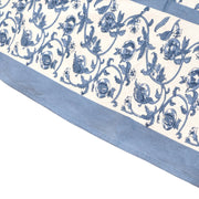 Close-up of the Caravan Home 71 x 106 Granada Cornflower Blue Tablecloth, showcasing intricate floral patterns with cornflower blue pomegranates on a white background.
