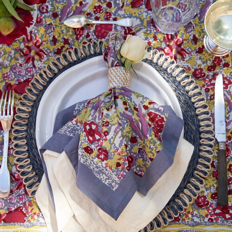 Caravan Home 71 x 106 Red & Grey Tablecloth, featuring a vibrant, handprinted design, elegantly set with napkin and silverware, embodying French garden inspiration.