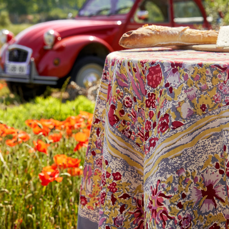 Caravan Home 59 x 86 Red & Grey Tablecloth on an outdoor table with a sandwich, featuring a floral pattern from the Jardin collection.