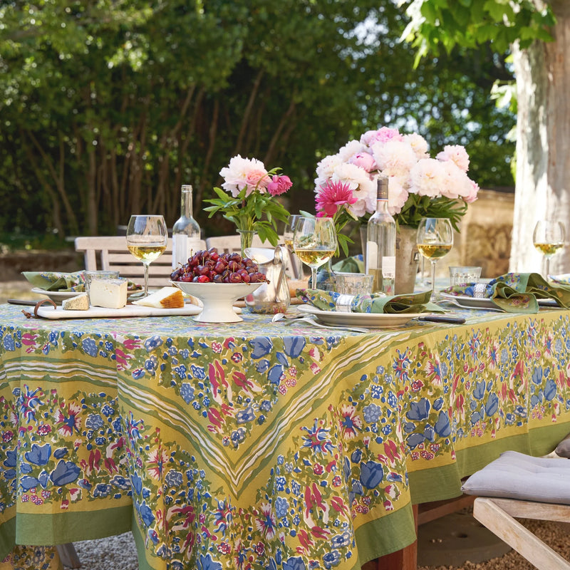 Jardin Blue & Vert Tablecloth on a dining table adorned with wine and cherries, showcasing the tablecloth's intricate floral design, ideal for elegant outdoor settings.
