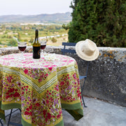 Caravan Home 59 x 86 Red & Green Tablecloth on a table with wine glasses and a hat, emphasizing French-inspired, artisan-crafted design.