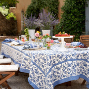 Caravan Home | 59 x 86 Granada Cornflower Blue Tablecloth elegantly adorns a party table with its intricate floral design, ideal for festive gatherings.