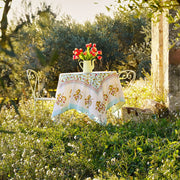 Caravan Home | 71 x 106 Fraises des Bois Blue Tablecloth on a garden table with a vase of red tulips, enhancing outdoor dining elegance.