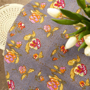 Caravan Home 59 x 86 Pansy Red & Grey Tablecloth on table, showcasing intricate floral and abstract patterns, handprinted on French linen for a classic, modern table setting.