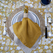 Forest Harvest Grey & Mustard Tablecloth displayed on a table setting with napkin, glass, and silverware, showcasing hand-printed fruit and foliage design.