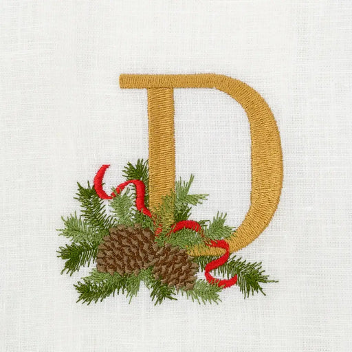 Winter Pine Monogram Towel, D, features a golden embroidered letter with pine sprigs, pinecones, and a red ribbon, perfect for festive kitchen elegance.