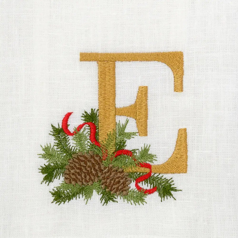 Arte Italica & Crown Linen Designs Winter Pine Monogram Towel, E, features a linen towel with a golden E and festive pine motif embroidery.