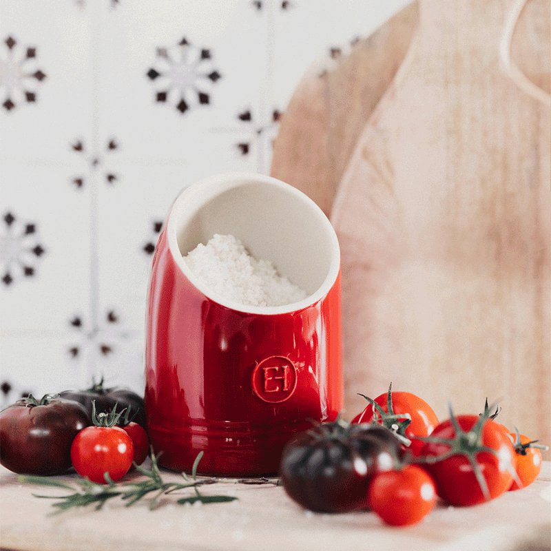Emile Henry | Burgundy Salt Pig filled with coarse salt on a cutting board, surrounded by tomatoes and herbs, exemplifying Athens Cooks' curated kitchen essentials.