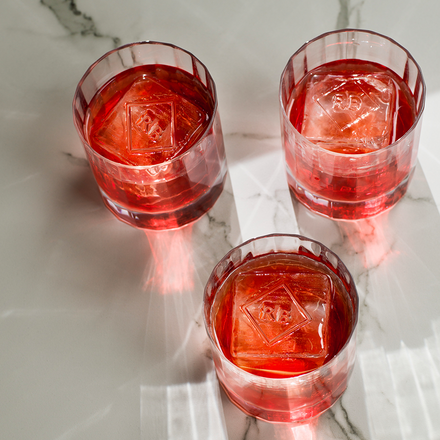 Richard Brendon | Double Old Fashioned Tumbler - Fluted, showcasing a group of elegant, weighty glasses with red liquid and ice, ideal for cocktails.