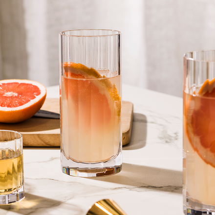 Richard Brendon | Fluted Highball Glasses featuring a slice of orange, embodying Art Deco elegance on a table, ideal for enhancing barware collections.