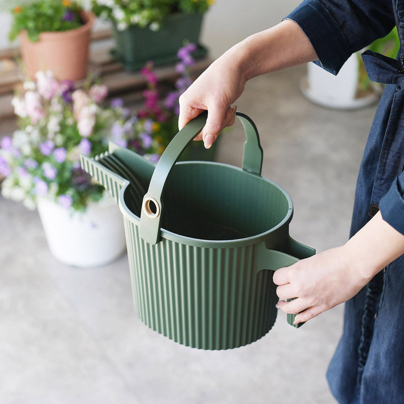 Hand carrying Hachiman Garden Beetle small watering can in Garden Green