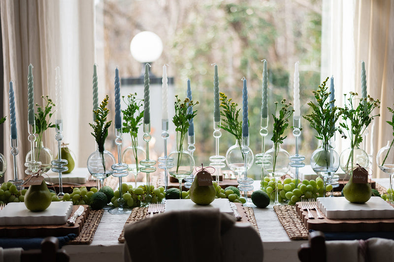 Clear Glass Large Pair Candlestick on a table with fruit and candles, showcasing elegance and style, perfect for enhancing dining settings.