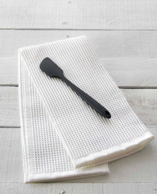 GIR | Mini Spatula - Black, ideal for kids, shown on a white towel, designed for scooping and mixing small portions.