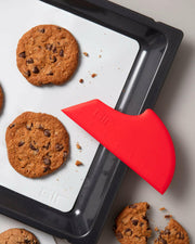 GIR Silicone Spatula with a ruled edge and broad curves, displayed next to a chocolate chip cookie on a tray. Perfect for versatile kitchen use.