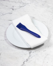 GIR | Basting Brush - Navy on a white towel, designed for precise and efficient tasks like applying egg wash or glazing ribs, showcased on a plate.