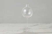 Etú Home | Clear Wine Glass Vase Medium: A unique vase featuring a glass sphere atop a wine glass stem, perfect for elegant table centerpieces and special occasions.