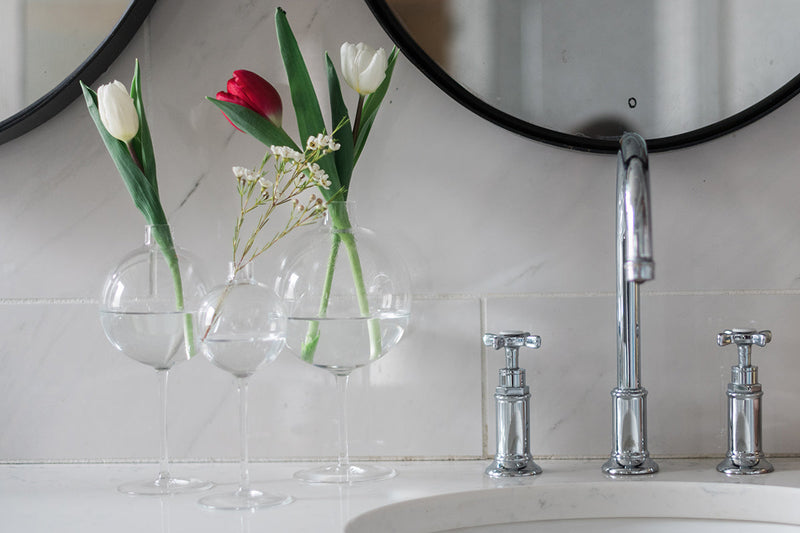 Etú Home | Clear Wine Glass Vase Medium, featuring a glass sphere atop a wine glass stem, elegantly displays flowers, perfect for weddings or dinner parties.
